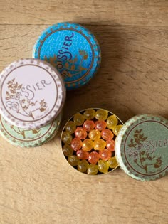 three small tins with candies in them on a table