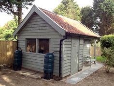 a small shed with two large barrels in front of it