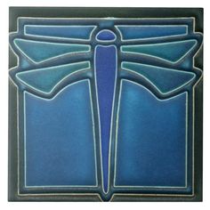 a blue and black tile with a large dragonfly on it's back side