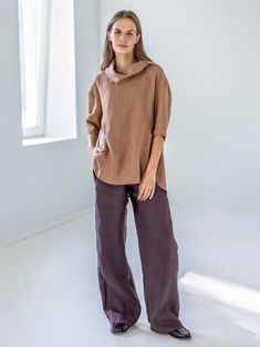 "Our roll neck linen top with side slits at the front & pleat at the back is light but rich with statement, like a luscious French ECLAIR. Offered in medium-weight linen.  STYLE DETAILS * Loose fit, longer at the back * Funnel neck  * 3/4 sleeves  * 2 side slits positioned at the front * Pleat at the back * Made from medium-weight linen SIZES & COLORS IN PICTURES * Model 1 wears size S/M in color Rusty. She is 176 cm (5'9\"). Bust - 81 cm (32\"), waist - 67 cm (26\"), hips - 90 cm (35\"). * Model 2 wears size S/M in color Golden Waves. She is 176 cm (5'9\"). Bust - 89 cm (33\"), waist - 70 cm (28\"), hips - 90 cm (35\"). NOTES ON SIZING & COLORS * Please note that linen shrinkage during the softening process cannot be predicted precisely. Therefore, each piece in the same size can vary 1-2 Oversized Linen Dress For Work, Fall Linen Tunic Blouse, Fall Ramie Tops, Brown Linen Blouse For Work, Brown Linen Relaxed Fit Tops, Brown Relaxed Fit Linen Top, Oversized Linen Tunic Tops, Relaxed Fit Linen Blouse In Flax Color, Oversized Chic Linen Blouse