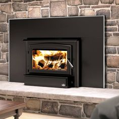 a wood burning stove sitting on top of a stone fireplace