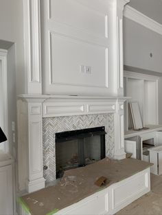 the fireplace is being installed in the living room with white walls and trimmings