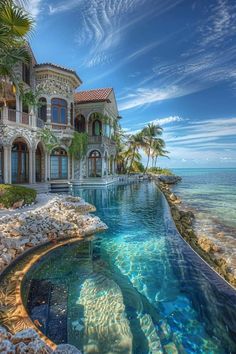 a large house with a pool next to it and palm trees in the front yard