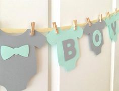 baby clothes are hung on the clothesline with clothes pegs attached to them, and one is wearing a bow tie