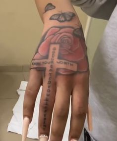 a person with a tattoo on their left hand and a cross on the other hand