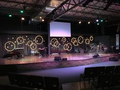 the stage is set up for an event with lights on it and chairs in front