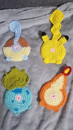 four crocheted animals sitting on top of a blanket