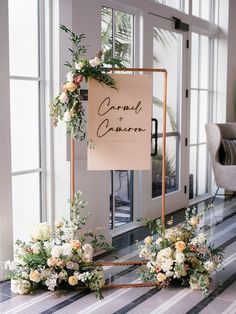 two floral arrangements are sitting on the floor next to a sign that says grand garden