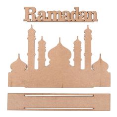 a cut out of wood with the name ramadan in arabic and mosques on it