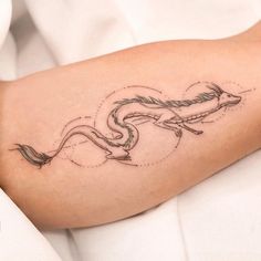 a tattoo on the arm of a woman with an arrow in her right hand and a snake coming out of it