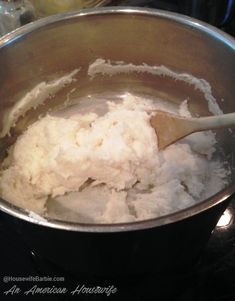 a metal bowl filled with white powder and a wooden spoon in it on top of a stove