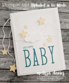 a baby card with gold stars on it and the words welcome baby written in white