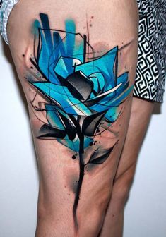 a woman's thigh with blue and black ink art work on the side of her leg