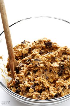 a bowl filled with oatmeal and raisins next to a wooden spoon