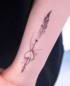 a woman's arm with a feather and arrow tattoo on the left side of her wrist