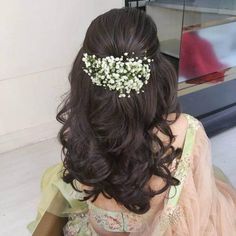 the back of a woman's head with flowers in her hair, sitting down