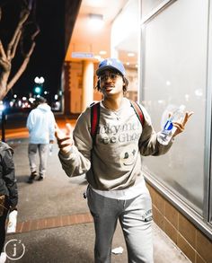 a man standing on the sidewalk with a bottle of water in his hand