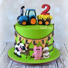 a birthday cake decorated with farm animals and tractors