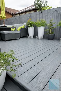 Modern garden design with anthracite grey decking Grey Fence And Decking, Decked Patio Ideas, Grey Garden Decking, Grey Pool Decking, Light Grey Fence Garden, Decked Seating Area, Plastic Decking Ideas, Dark Grey Decking, Grey Decking Ideas Garden