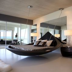 a bedroom with a hammock hanging from the ceiling and pillows on the bed