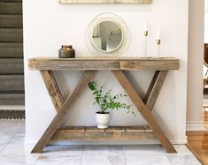 a wooden table with a potted plant on it and a mirror above the table