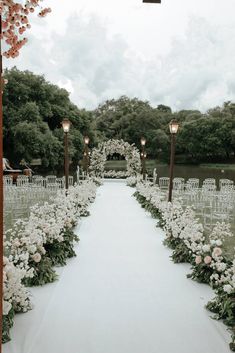 the aisle is lined with white flowers and lit up by street lamps on either side