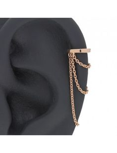 an earring with chains attached to it on top of a black mannequin