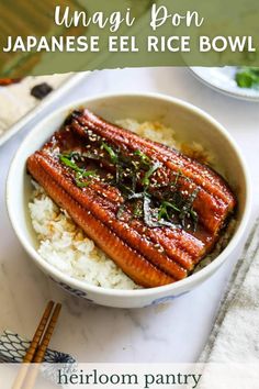 a bowl filled with rice and some kind of fish on top of it next to chopsticks