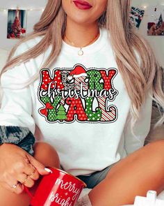 a woman sitting on a couch holding a red coffee mug with merry christmas yay