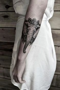 an elephant tattoo on the left arm