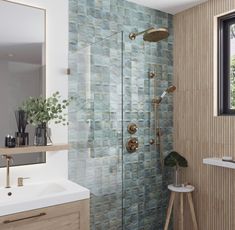 a bathroom with a walk in shower next to a white sink and wooden counter top