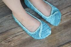 a woman's feet wearing blue crocheted shoes