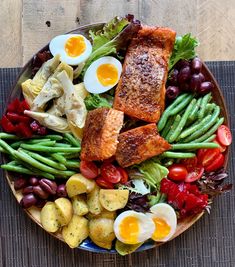 a plate filled with meat, vegetables and eggs