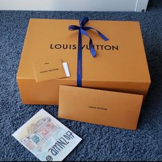 the louis vuitton box is open and it has a blue ribbon on it