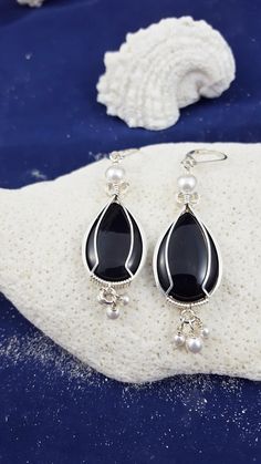 These Onyx earrings are wire wrapped with sterling silver square wire and topped with a 6mm white Swarovski faux pearl and 3 of the same 3mm pearls dangle from the bottom of each earring. They are hung off of sterling silver leverback earwires. Beautiful for any occasion. Elegant Wire Wrapped Silver-plated Earrings, Black Sterling Silver Jewelry With Pearl Drop, Elegant Silver-plated Ear Wire Earrings, Elegant Silver Plated Ear Wire Earrings, Elegant Teardrop Silver Plated Wire Earrings, Elegant Silver Plated Drop Earrings, Silver Teardrop Wire Wrapped Pearl Earrings, Elegant Silver Wire Wrapped Pearl Earrings, Silver Dangle Wire-wrapped Pearl Earrings