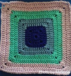 a crocheted square with a blue center