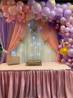 the table is covered with pink and purple balloons