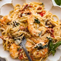 a white plate topped with pasta and shrimp