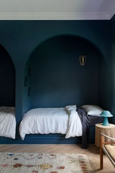 two beds in a room with blue walls