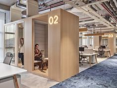 two people sitting in an office cubicle with the number 20 on it's wall