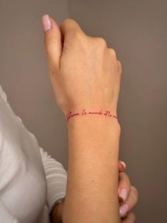 a woman's arm with a red tattoo on it