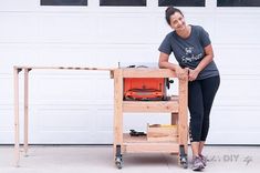 a woman standing next to a workbench in front of a white garage door