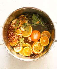 oranges, herbs and spices are cooking in a pot