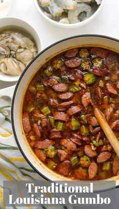 a pot filled with sausage and green peppers next to bowls of food on a table