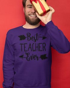 a man holding a present box over his face with the words best teacher ever written on it