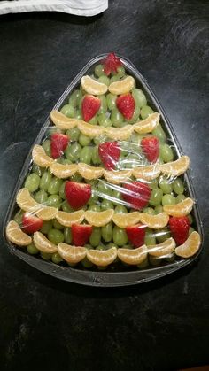 a christmas tree made out of grapes, oranges and strawberries