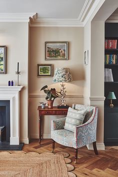 a living room filled with furniture and a fire place next to a book shelf on top of a hard wood floor