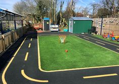 an artificial basketball court in a backyard with grass and yellow lines painted on the ground