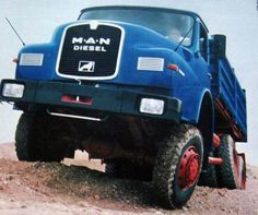 a blue dump truck parked on top of a dirt hill