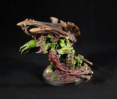 an alien warhammer with green and red paint on it's body, standing in front of a black background